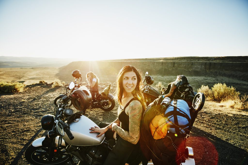uśmiechnięta motocyklistka na punkcie widokowym podczas wycieczki